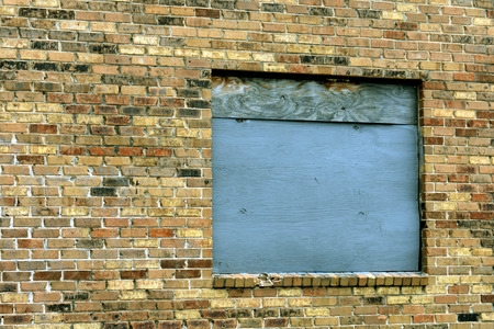 Blue plywood window on multicolor brick wall.の写真素材