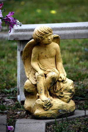 Sitting child angel headstone sculpture gold color stone.の写真素材