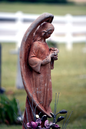 side view cemetery angel with full wings and terracotta colored.の写真素材