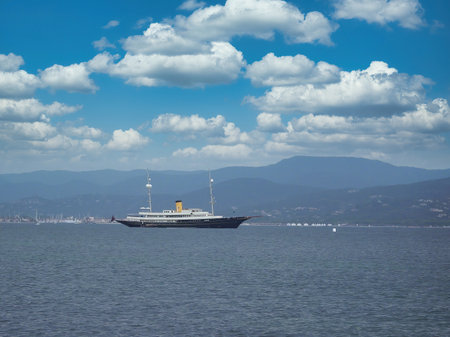 Saint Tropez, France - May 05th 2018: A german photographer exploring the harbor, taking pictures of an exclusive historical yacht outside of it at a cloudy day in spring.のeditorial素材