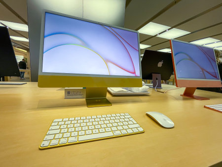 Cologne, Germany - September 30th 2021: A german photographer visiting an Apple Store in a shopping mall, collecting information and taking pictures of the all new Apple iMac 2021 in different colors.のeditorial素材