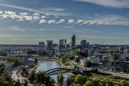 Vilnius, Lithuania - July 17th 2024: A German photographer visiting Vilnius, taking pictures of sight of the city, here the view over the river Vilnia to the business district.のeditorial素材