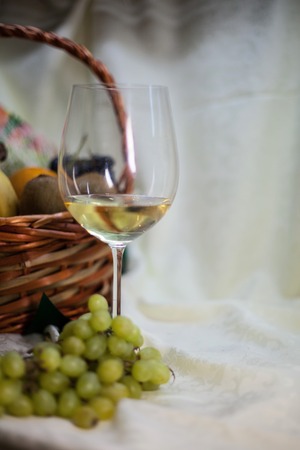 wine and fresh fruits in a basket on a vintage backgroundの写真素材