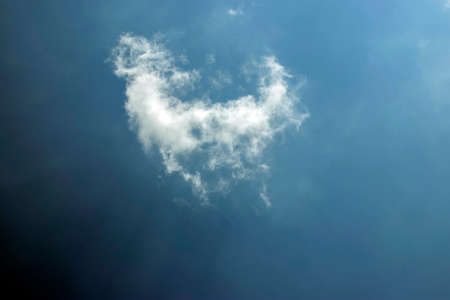 A piece of isolated or torn white cloud in the pure royal dark blue skyの写真素材