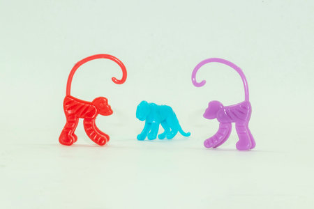 The toys include monkeys and giraffes. The toys are made of plastic, which children play with. Here are some purple and green toysの写真素材