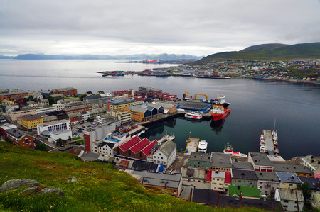 The northmost city in the world - center of a scandinavian town of Hammerfest visible from a hill, with a seaport in the middle, and industrial district in the background. Beyond the Arctic Circle during the day.のeditorial素材