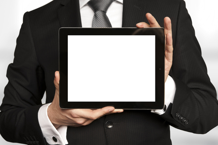 Man in suit, shirt and tie holding a tablet computer with blank displayの写真素材