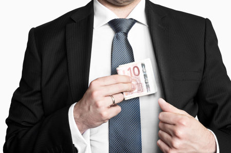 Businessman wearing suit and tie hiding money in his pocket
