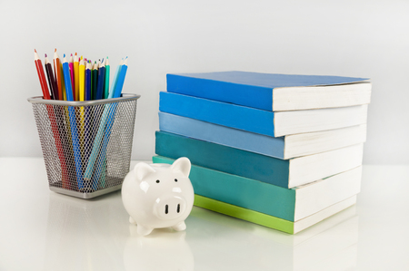 Piggy bank, books and colorful pencils - saving on school suppliesの写真素材