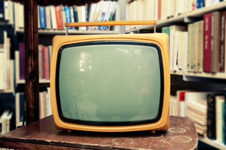 Retro TV set in vintage setting - old living room, with lots of books in the backgroundの写真素材