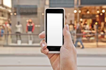 Smartphone with empty screen in woman hand in a shopping center - shopping application displayの写真素材