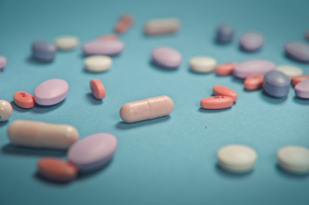 Lots of medical pills on green - blue backgroundの写真素材