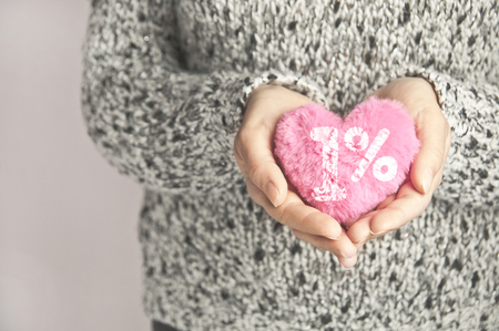 Donating one percent to charity concept - pink heart in woman's handの写真素材