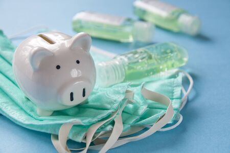 Piggy bank and face masks - costs of pandemics precautions conceptの写真素材