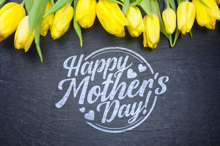 Happy Mother's Day! yellow tulips on black background, greeting cardの写真素材