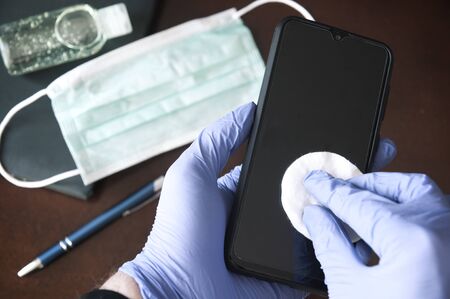 Pandemics precaution concept  - desinfection of a mobile phoneの写真素材