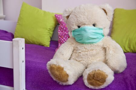 Kids health safety - teddy bear wearing face mask. Anti virus protection concept.の写真素材