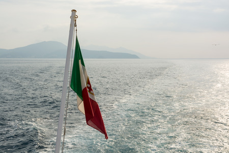 Italian flag on the boat in Mediterranean seaの写真素材