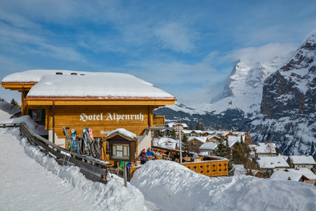 MURREN, SWITZERLAND - FEBRUARY 4, 2018: Tourists enjoying beautiful winter day on sunny terrace with incredible views on  Bernese Alps peaks in Murren, Switzerlandのeditorial素材