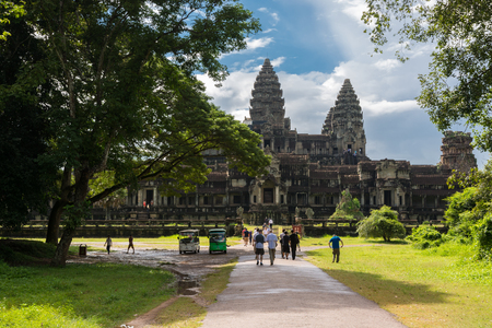 SIEM REAP, CAMBODIA - OCTOBER 19, 2014 - Group of tourists walking towards the famous Angkor Wat temple near Siem Reap in Cambodia during the peak seasonのeditorial素材