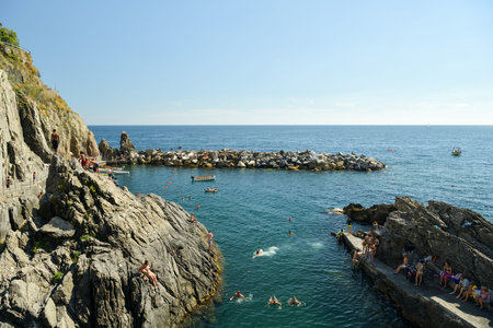 Manarola, Italy - June 29, 2018: People swimming in harbor in Manarola, Italy during hot summer day in June 2018のeditorial素材