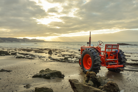 Napier, New Zealand - February 14, 2015: Old tractor standing on the beach near Cape Kidnappers close to city of Napier in New Zealand during February 2015のeditorial素材