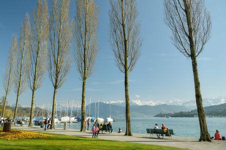 Luzern, Switzerland - March 31, 2019: People enjoying their time on promenade at the shores of Lake Lucerne in Luzern, Switzerland during sunny dayのeditorial素材