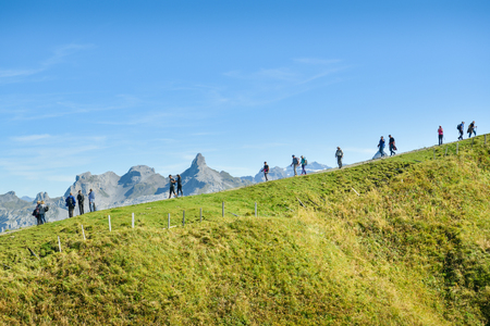 Stoos, Switzerland - September 20, 2019: Tourists walking in line on ridge close to Fronalpstock peak above the village of Stoos, Switzerland during one of the last summer days in 2019のeditorial素材