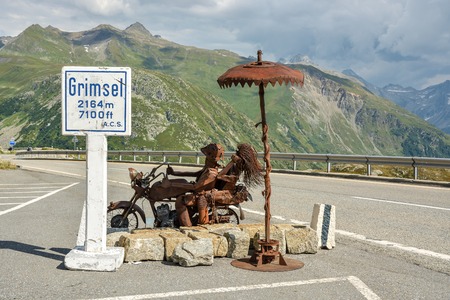 Old rusty metal sculpture representing couple of riders on motorbike on top of Grimselpass high alpine route in canton of Bern, Switzerlandのeditorial素材