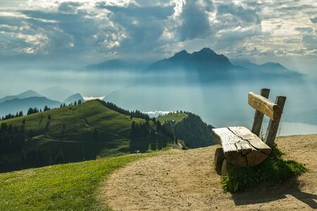 Wooden bench with beautiful views on Swiss Alps close to top of Mount Rigi in Switzerlandの写真素材