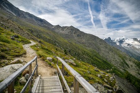 Small wooden bridge on hiking trail close to Kreuzboden above the Saas-Grund village in Swis Alpsの写真素材