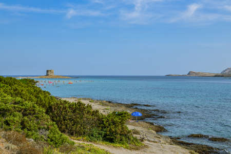 Stintino, Italy - August 31, 2019: People having bath in Mediterranean Sea in Stintino, Italy with beautiful views on historic tower during end of summer in 2019のeditorial素材
