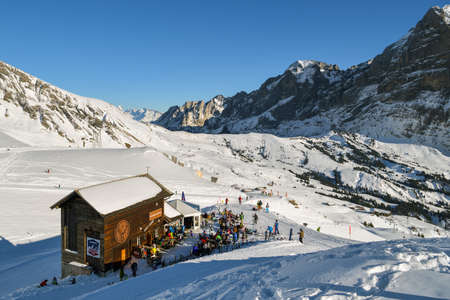 Grindelwald, Switzerland - December 30, 2019: Skiers taking break in small restaurant on the slopes near Grindelwald First, Switzerland during sunny day in December 2019のeditorial素材