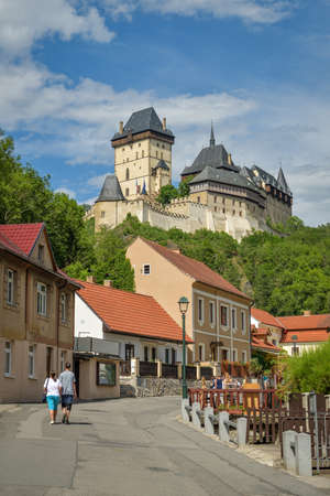 Karlstejn, Czech Republic - June 21, 2019:  Couple walking on main street under the Karlstejn castle in Karlstejn, Czech Republic during beautiful sunny day in summer 2019のeditorial素材