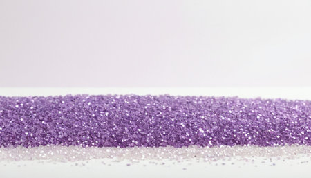 a dense, uniform row of sparkling purple glitter, creating a distinct horizontal band. Below this band, a scattering of lighter, almost translucent particles suggests a subtle transition or a different texture. The glitter shimmers with captured light, and the overall effect is soft and dreamy, with a gentle gradient of light pink subtly present in the upper background. This abstract composition is adding a touch of sparkle and elegance to various projects.の素材