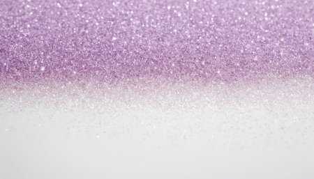 A soft and luminous background is created by a gradient of lavender glitter transitioning into white. The fine glitter particles catch the light, producing a gentle shimmering effect. This abstract texture is backgrounds in projects, adding a touch of sparkle and elegance without being overpowering. The smooth transition between colors and the subtle sparkle evoke a sense of softness and light. The is clean and bright, themes related to celebration, beauty, or creative endeavors.の素材