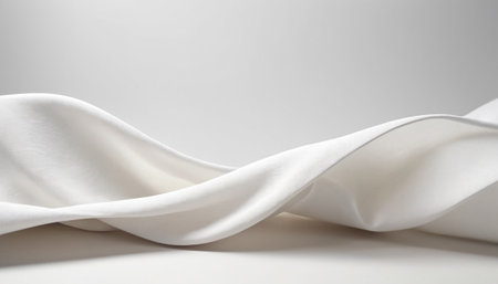 presents a soft and abstract background formed by gentle waves of white fabric. The is artfully draped, creating flowing lines and subtle undulations. The lighting is soft, casting delicate shadows that highlight the smooth texture and feel of the cloth. The minimalist composition emphasizes purity and sophistication.の素材
