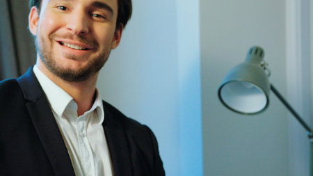 Young attractive business man in suit with notebook smiling and possing on camera in the stylish...