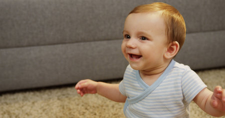 Close up of cute baby boy laughing and making happy face in the room. Portrait shot. Indoor