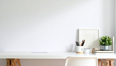Close up of minimal workspace with blank white wall, office supplies and copy space on the table.の素材