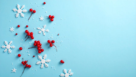 Snowflakes and rowan berries on blue background, flat layの素材