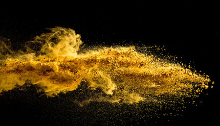 Explosion of yellow powder on black background. Abstract colored background.の素材