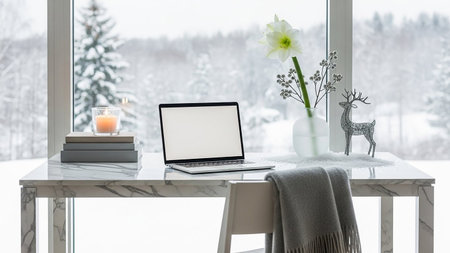 Laptop with blank screen on table in front of window with winter landscapeの素材