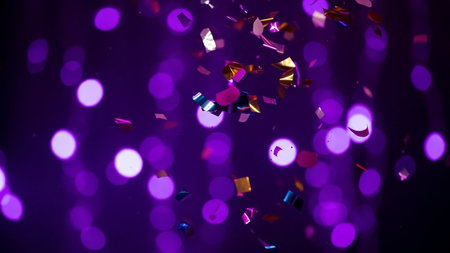 Purple bokeh of confetti on a black background.の素材