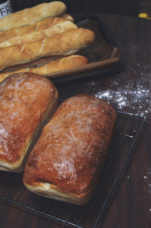 Freshly baked baguettes on the wooden table. Selective focus.