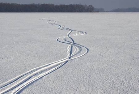 traces of skis in the snow on a frozen lake