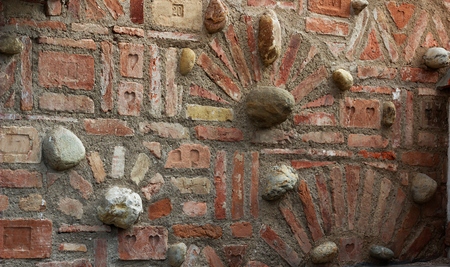 old brick wall with decorative bricks and natural stones between themの写真素材