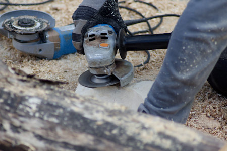 The man with the angular grinder grinds the wood