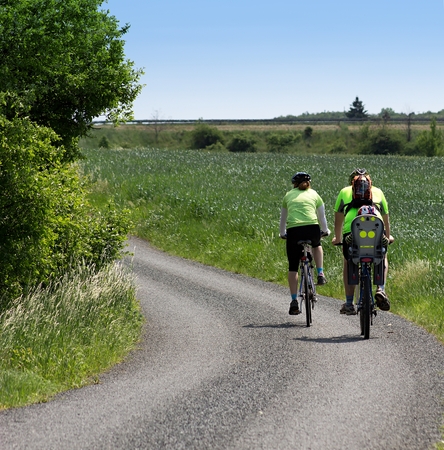 Family riding on bicycles with children on the roadの写真素材