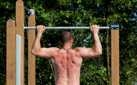 Man exercising on the bar in the park